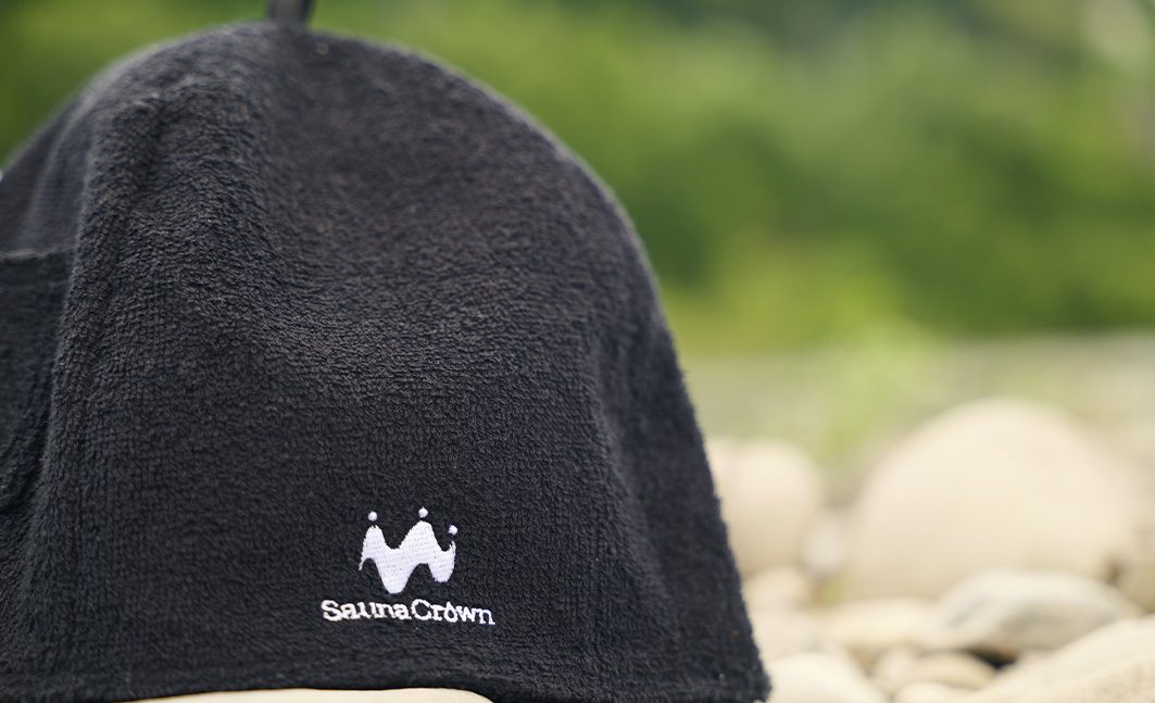 岩場に置かれた Sauna Crown の黒いサウナハット